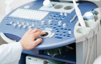 Sonographer using ultrasound machine at work.